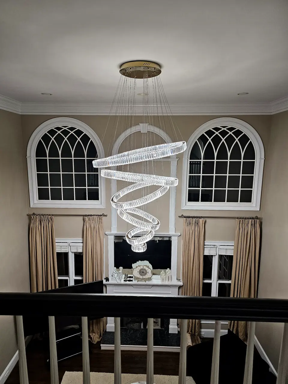 Two-story foyer with tiered chandelier and arched windows