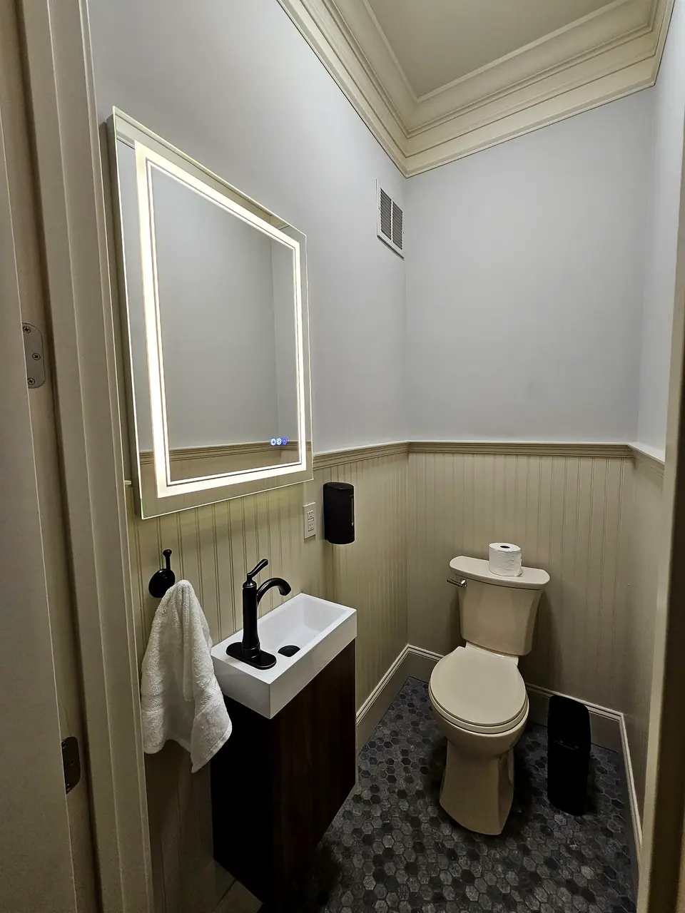 Compact bathroom with new vanity, toilet and mirror